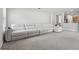 Bright living room featuring a large white sectional couch, carpeted floors and neutral paint at 20102 Oakflower Ave, Tampa, FL 33647