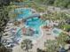 Resort-style community pool with slides, jacuzzi, bridge, and palm trees, creating a relaxing oasis at 20102 Oakflower Ave, Tampa, FL 33647