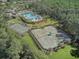 Aerial view of the community tennis courts, pool, and surrounding landscape at 20102 Oakflower Ave, Tampa, FL 33647