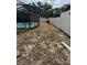 Backyard with a screened-in pool and a white privacy fence around the perimeter at 2026 Aaron Pl, Clearwater, FL 33760