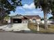 Charming single-story home features a carport, white picket fence, and lush landscaping at 2026 Aaron Pl, Clearwater, FL 33760