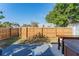 A fenced backyard with a deck, greenery, and space for outdoor activities and relaxation under a bright blue sky at 2035 29Th N Ave, St Petersburg, FL 33713