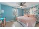 Comfortable bedroom with a ceiling fan, window, and floral curtains on tile flooring at 2035 29Th N Ave, St Petersburg, FL 33713