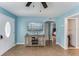 Bright living room with blue walls, wood-look floors, TV, and inviting doorway to bedroom at 2035 29Th N Ave, St Petersburg, FL 33713