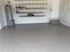 Clean garage features gray flooring and storage shelves for organization at 2100 Aqui Esta Dr, Punta Gorda, FL 33950