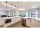 Bright kitchen features pendant lighting, stainless steel appliances, and ample cabinet space at 2100 Aqui Esta Dr, Punta Gorda, FL 33950