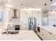 Modern kitchen boasts white cabinetry, stainless steel appliances, and an island with marble countertops at 2100 Aqui Esta Dr, Punta Gorda, FL 33950