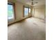 Cozy bedroom with neutral carpet, ceiling fan, large windows and closet space for organized storage at 2360 Irish Ln # 16, Clearwater, FL 33763