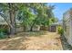 A spacious backyard with a large tree, storage shed and wooden fence at 2604 E Chelsea St, Tampa, FL 33610