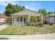 Charming single-story home with light beige siding, a well-manicured lawn, and a cute white picket fence at 2604 E Chelsea St, Tampa, FL 33610