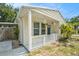 Inviting front porch with cream supports, hanging decorations, and a freshly painted dark green front door at 2604 E Chelsea St, Tampa, FL 33610