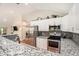 Bright kitchen featuring white cabinets, granite countertops, stainless steel appliances, and modern fixtures at 2604 E Chelsea St, Tampa, FL 33610