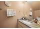 A well-lit powder room with a granite countertop, decorative fixtures, and a decorative flower on the wall at 3413 W Kirby St, Tampa, FL 33614
