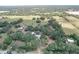 Gorgeous aerial view featuring the home nestled among mature trees, surrounded by expansive fields at 3544 Porter Rd, Lithia, FL 33547
