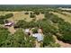 Wide aerial view showcasing property with multiple buildings amid lush greenery at 3544 Porter Rd, Lithia, FL 33547