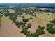 Beautiful aerial view of a rural property featuring open pasture, mature trees, and distant residential area at 3544 Porter Rd, Lithia, FL 33547