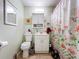 This bathroom features a sink vanity, toilet, and a shower with a charming floral curtain at 3544 Porter Rd, Lithia, FL 33547