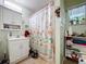 Cozy bathroom featuring a sink vanity, medicine cabinet and a shower with a floral curtain at 3544 Porter Rd, Lithia, FL 33547