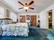 Bedroom features carpet, ceiling fan, wooden closet doors, and a bed with patterned bedding at 3544 Porter Rd, Lithia, FL 33547