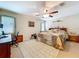 Bedroom featuring a ceiling fan, windows, work station, and a bed with a colorful patchwork quilt at 3544 Porter Rd, Lithia, FL 33547