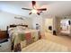 Spacious bedroom featuring a ceiling fan, a bed with a multicolored quilt, and a neutral color scheme at 3544 Porter Rd, Lithia, FL 33547