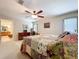 Bright bedroom features a ceiling fan, beige walls, and a bed with a colorful patchwork quilt at 3544 Porter Rd, Lithia, FL 33547