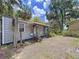 Exterior view of quaint cottage with metal siding, a covered porch, and surrounding trees at 3544 Porter Rd, Lithia, FL 33547