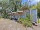 Angled exterior view of metal-sided home with covered porch, foliage, and yard at 3544 Porter Rd, Lithia, FL 33547