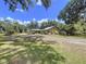 Residential property showcasing the facade and yard with mature trees under a blue sky at 3544 Porter Rd, Lithia, FL 33547