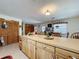 Kitchen area with tile flooring, wooden cabinets, ample counter space, and laundry closet nearby at 3544 Porter Rd, Lithia, FL 33547