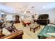 Open living room featuring tile flooring, ceiling fan, natural lighting, and multiple seating areas at 3544 Porter Rd, Lithia, FL 33547