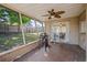 Screened in back patio with ceiling fan overlooking spacious yard and a grill at 3640 Cheswick Dr, Holiday, FL 34691