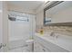 Clean bathroom features white tiling, a marble sink, and an updated bathtub at 3640 Cheswick Dr, Holiday, FL 34691