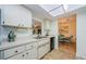 Efficient kitchen with white cabinets, a breakfast bar, and views into the dining area, creating an open feel at 368 Perth Ct # 368, Dunedin, FL 34698