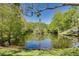 A tranquil pond surrounded by mature trees reflecting in the calm waters of this beautiful outdoor space at 368 Perth Ct # 368, Dunedin, FL 34698