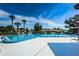 Community pool with lounge chairs and mature trees offers a relaxing outdoor retreat at 368 Perth Ct # 368, Dunedin, FL 34698