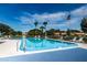 Community pool with ample seating, mature trees, and clear blue water at 368 Perth Ct # 368, Dunedin, FL 34698