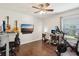 Bedroom featuring wood floors, ceiling fan, guitars, exercise bike, and desk with computer setup at 3713 Lonewood Ct, Land O Lakes, FL 34638