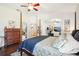 Bedroom featuring wood floors, four-poster bed, ceiling fan, and view to exercise room at 3713 Lonewood Ct, Land O Lakes, FL 34638