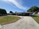 Charming single-story home with a well-manicured front lawn and a long driveway leading to an attached garage at 378 79Th Ne Ave, St Petersburg, FL 33702