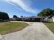 Charming single-story home with a well-manicured front lawn and a long driveway leading to an attached garage at 378 79Th Ne Ave, St Petersburg, FL 33702