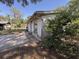 Exterior side view showcasing weathered siding, and an overgrown backyard at 37810 Silver Pines Ave, Zephyrhills, FL 33542