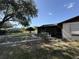 View of the side of the property with a chainlink fence and trees in the background at 37810 Silver Pines Ave, Zephyrhills, FL 33542