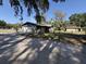 Exterior view of the home featuring a garage, front porch and unkempt lawn at 37810 Silver Pines Ave, Zephyrhills, FL 33542