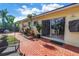 Backyard patio with lush tropical landscaping and a sliding glass door at 3843 Neptune Se Dr, St Petersburg, FL 33705