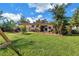 A spacious backyard with a well-kept lawn, patio seating, and flourishing trees at 3843 Neptune Se Dr, St Petersburg, FL 33705