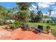 Backyard patio with mature trees and grassy play area at 3843 Neptune Se Dr, St Petersburg, FL 33705