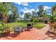 Sprawling backyard showcasing brick patio, lush tropical landscaping and playground area at 3843 Neptune Se Dr, St Petersburg, FL 33705