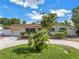 Charming single-story home with a circular driveway, lush landscaping, and attached one car garage at 3843 Neptune Se Dr, St Petersburg, FL 33705