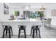 Modern kitchen featuring stainless steel appliances, quartz countertops, breakfast bar, and backyard views at 3843 Neptune Se Dr, St Petersburg, FL 33705
